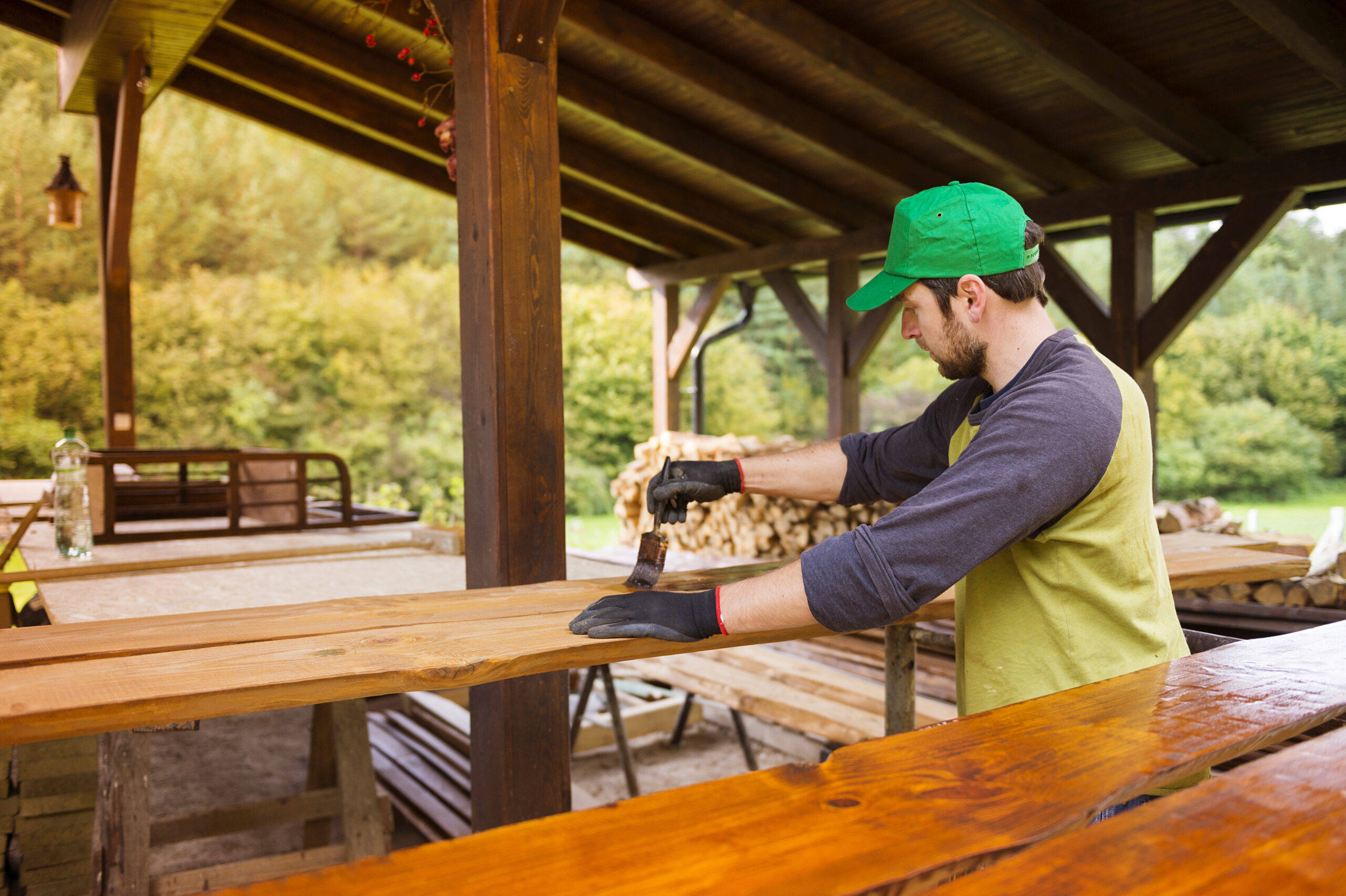 graphicstock handyman varnishing pine wooden planks in patio outside the new house BAGftp2nb scaled